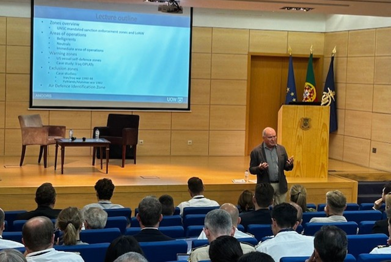 A man speaking to an auditorium at a conference